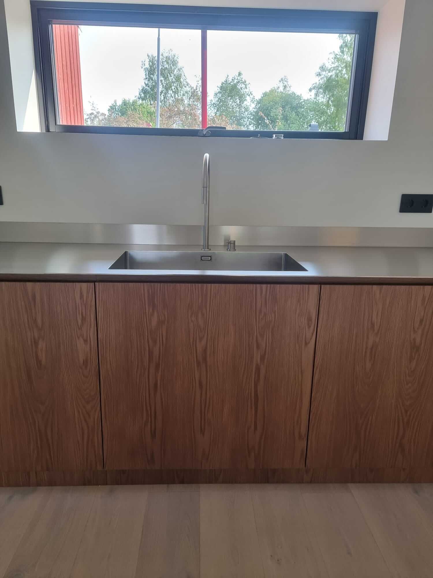 Wooden kitchen cabinets with smooth finish and white floor.
